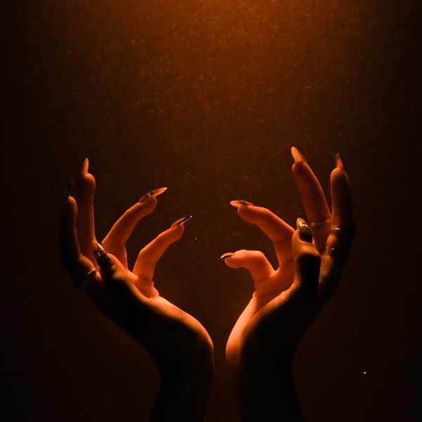 Silhouette of a person in a calm, balanced pose against a violet glow.